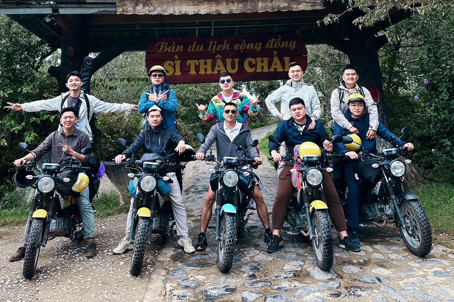 Riders with Yamaha PG1 motorbikes at the Sì Thâu Chải village gate on the Lai Châu Loop