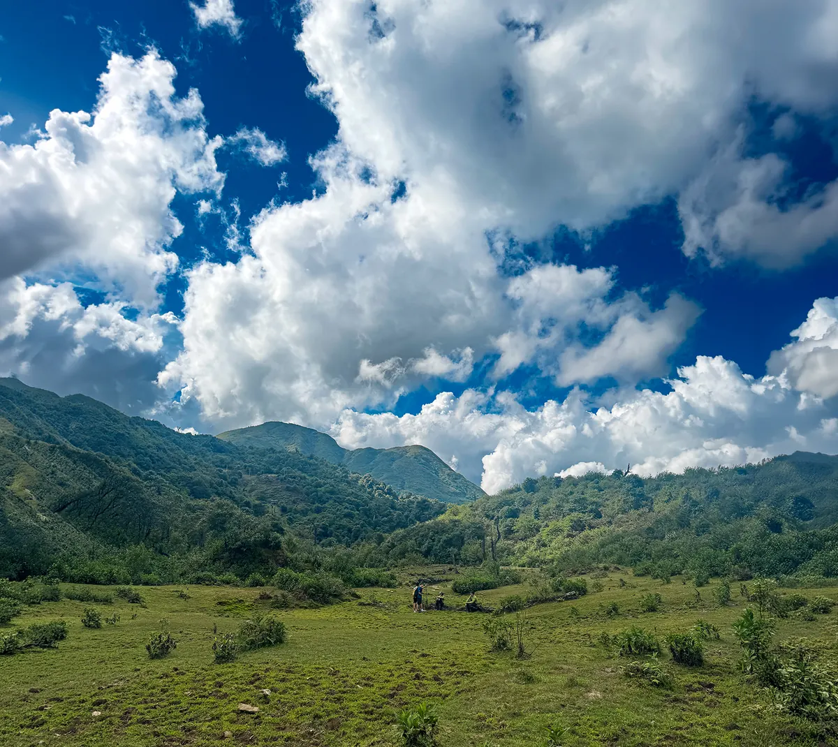 Open green valley under big clouds