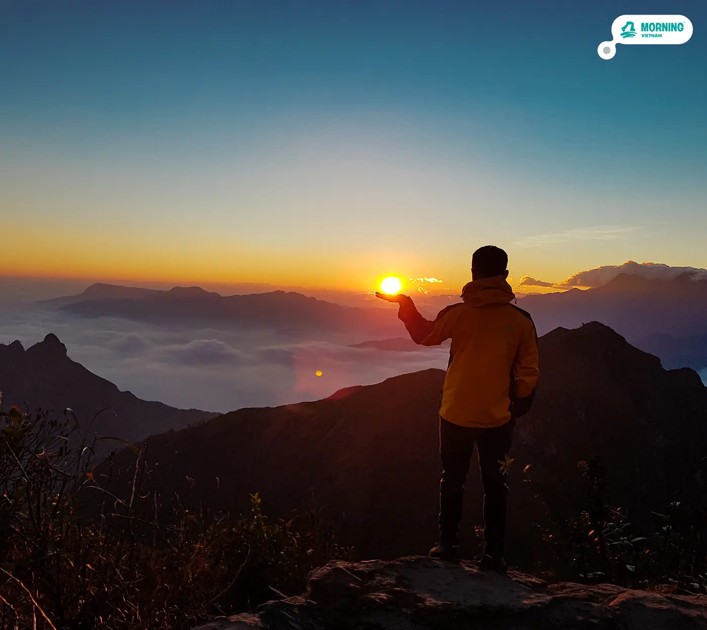 Holding the setting sun above a sea of clouds